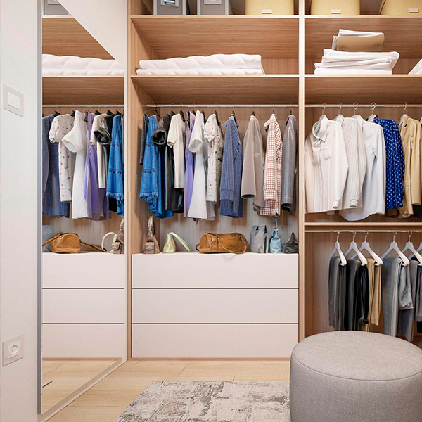 Un dressing spacieux rempli de vêtements suspendus et de chaussures bien organisées sur des étagères.