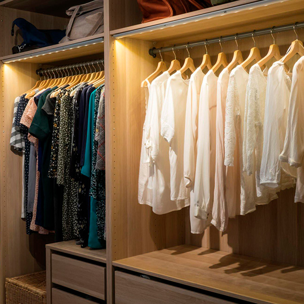 Un dressing spacieux avec des vêtements suspendus sur des portants.